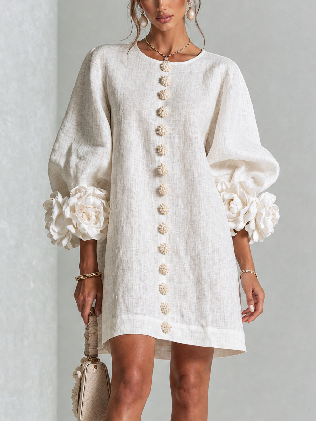 The Rosalie Button-Down Mini Dress in white, with rose-knot cuffs and floral buttons